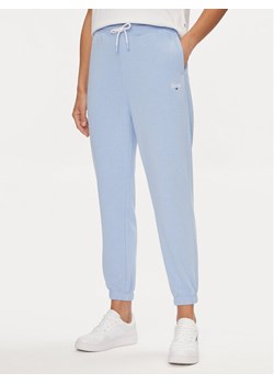 Tommy Jeans Spodnie dresowe Script DW0DW17771 Błękitny Relaxed Fit ze sklepu MODIVO w kategorii Spodnie damskie - zdjęcie 181159825