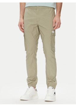 Calvin Klein Jeans Joggery J30J327614 Zielony Slim Fit ze sklepu MODIVO w kategorii Spodnie męskie - zdjęcie 181166979