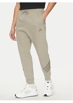 adidas Spodnie dresowe Future Icons 3-Stripes JD4862 Beżowy Regular Fit ze sklepu MODIVO w kategorii Spodnie męskie - zdjęcie 181169736