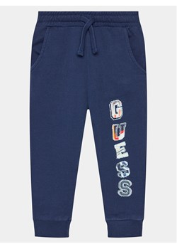 Guess Spodnie dresowe N4GQ11 KA6R3 Granatowy Regular Fit ze sklepu MODIVO w kategorii Spodnie chłopięce - zdjęcie 181170187