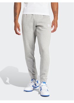 adidas Spodnie dresowe adicolor 3-Stripes IM9318 Szary Slim Fit ze sklepu MODIVO w kategorii Spodnie męskie - zdjęcie 181172935