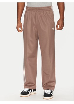 adidas Spodnie dresowe adicolor Firebird JP1067 Beżowy Baggy Fit ze sklepu MODIVO w kategorii Spodnie męskie - zdjęcie 181178019