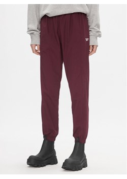 Reebok Spodnie dresowe Classics Franchise IL4627 Bordowy Relaxed Fit ze sklepu MODIVO w kategorii Spodnie damskie - zdjęcie 181886887