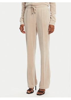 Juicy Couture Spodnie dresowe Tina JCAPW045 Beżowy Regular Fit ze sklepu MODIVO w kategorii Spodnie damskie - zdjęcie 181945559