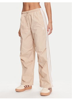 adidas Spodnie dresowe 3-Stripes Woven Parachute IY7252 Beżowy Loose Fit ze sklepu MODIVO w kategorii Spodnie damskie - zdjęcie 182594139