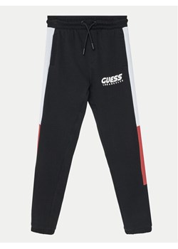 Guess Spodnie dresowe L5RQ11 KA6R4 Czarny Regular Fit ze sklepu MODIVO w kategorii Spodnie chłopięce - zdjęcie 182597267
