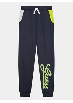 Guess Spodnie dresowe L3YQ34 KA6R3 Granatowy Relaxed Fit ze sklepu MODIVO w kategorii Spodnie chłopięce - zdjęcie 182607995