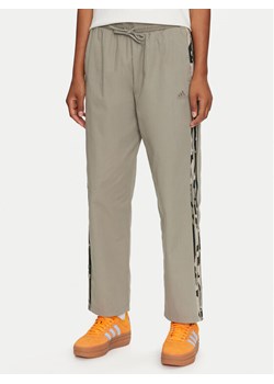 adidas Spodnie dresowe Essentials Camo-Print 3-Stripes IY1686 Zielony Loose Fit ze sklepu MODIVO w kategorii Spodnie damskie - zdjęcie 182645885