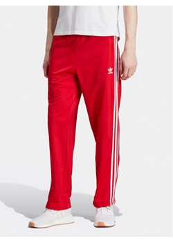 adidas Spodnie dresowe adicolor Classics Firebird IJ7057 Czerwony Regular Fit ze sklepu MODIVO w kategorii Spodnie męskie - zdjęcie 182647356