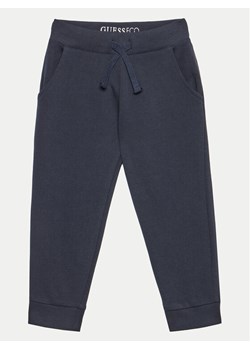 Guess Spodnie dresowe N93Q17 KAUG0 Granatowy Relaxed Fit ze sklepu MODIVO w kategorii Spodnie chłopięce - zdjęcie 182649028