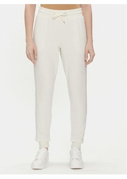 Tommy Hilfiger Spodnie dresowe UW0UW04785 Écru Regular Fit ze sklepu MODIVO w kategorii Spodnie damskie - zdjęcie 182654009