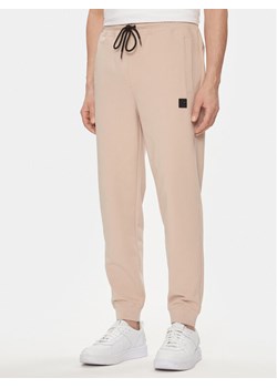 Hugo Spodnie dresowe Dimacs 50509457 Beżowy Relaxed Fit ze sklepu MODIVO w kategorii Spodnie męskie - zdjęcie 182666429
