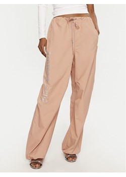 Juicy Couture Spodnie dresowe Ayla JCWBJ24306 Beżowy Loose Fit ze sklepu MODIVO w kategorii Spodnie damskie - zdjęcie 182669546