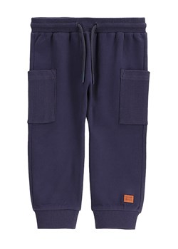 Coccodrillo Spodnie dresowe WC5120101SBN Granatowy Regular Fit ze sklepu MODIVO w kategorii Spodnie chłopięce - zdjęcie 182671626