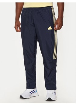adidas Spodnie dresowe House of Tiro IW3582 Granatowy Regular Fit ze sklepu MODIVO w kategorii Spodnie męskie - zdjęcie 182677435