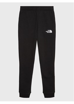 The North Face Spodnie dresowe Teen NF0A82EO Czarny Regular Fit ze sklepu MODIVO w kategorii Spodnie chłopięce - zdjęcie 182683439