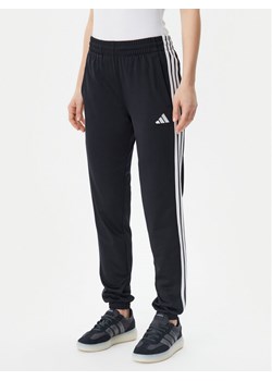 adidas Spodnie dresowe Tricot 3-Stripes JF3383 Czarny Regular Fit ze sklepu MODIVO w kategorii Spodnie damskie - zdjęcie 182684309