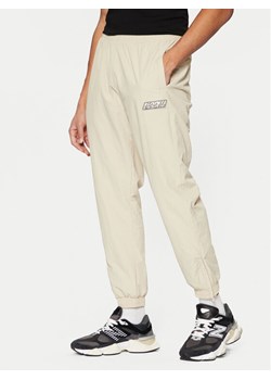 Karl Kani Spodnie dresowe Sport Patch Essential 60030075 Beżowy Relaxed Fit ze sklepu MODIVO w kategorii Spodnie męskie - zdjęcie 182687525
