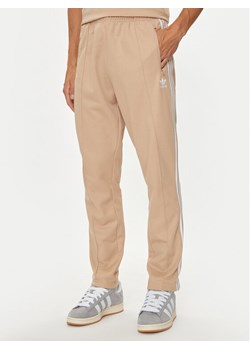 adidas Spodnie dresowe adicolor Classics Beckenbauer IZ1857 Beżowy Slim Fit ze sklepu MODIVO w kategorii Spodnie męskie - zdjęcie 182694467