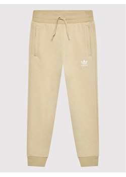 adidas Spodnie dresowe adicolor HK2860 Beżowy Regular Fit ze sklepu MODIVO w kategorii Spodnie chłopięce - zdjęcie 182699258