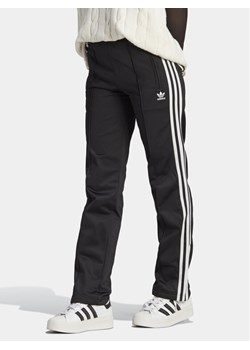 adidas Spodnie dresowe adicolor Classics Firebird IL8763 Czarny Regular Fit ze sklepu MODIVO w kategorii Spodnie damskie - zdjęcie 182709175