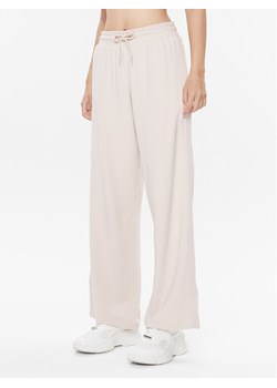 Tommy Hilfiger Spodnie dresowe UW0UW04771 Beżowy Relaxed Fit ze sklepu MODIVO w kategorii Spodnie damskie - zdjęcie 182709657