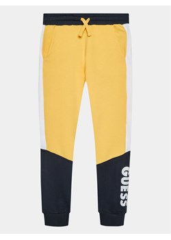 Guess Spodnie dresowe L3BQ11 KAX73 Żółty Regular Fit ze sklepu MODIVO w kategorii Spodnie chłopięce - zdjęcie 182714657