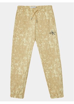 Calvin Klein Jeans Spodnie dresowe Second Skin IB0IB01932 Beżowy Relaxed Fit ze sklepu MODIVO w kategorii Spodnie chłopięce - zdjęcie 182716037