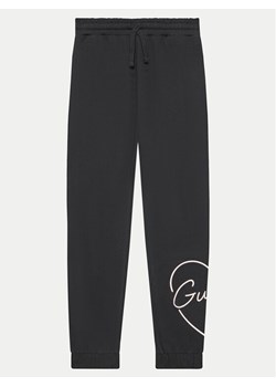 Guess Spodnie dresowe J4YQ16 KA6R3 Czarny Relaxed Fit ze sklepu MODIVO w kategorii Spodnie chłopięce - zdjęcie 182721007