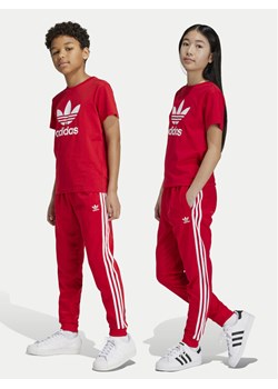 adidas Spodnie dresowe adicolor SST IX7631 Czerwony Regular Fit ze sklepu MODIVO w kategorii Spodnie dziewczęce - zdjęcie 182726168