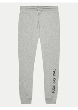 Calvin Klein Jeans Spodnie dresowe IU0IU00604 Szary Regular Fit ze sklepu MODIVO w kategorii Spodnie chłopięce - zdjęcie 182727378