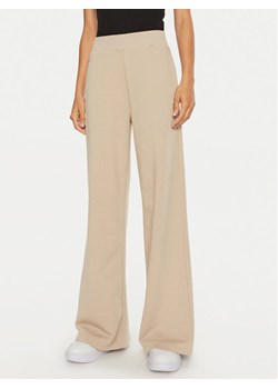 Calvin Klein Jeans Spodnie dresowe J20J222597 Beżowy Relaxed Fit ze sklepu MODIVO w kategorii Spodnie damskie - zdjęcie 182727495