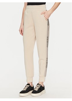 Guess Spodnie dresowe W5RB00 KBYE2 Écru Regular Fit ze sklepu MODIVO w kategorii Spodnie damskie - zdjęcie 182734686