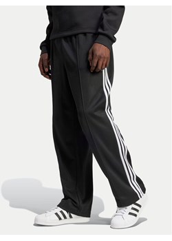 adidas Spodnie dresowe adicolor Firebird IZ4801 Czarny Baggy Fit ze sklepu MODIVO w kategorii Spodnie męskie - zdjęcie 182738338