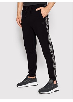 Guess Spodnie dresowe Z2YB19 K6ZS1 Czarny Regular Fit ze sklepu MODIVO w kategorii Spodnie męskie - zdjęcie 182740917