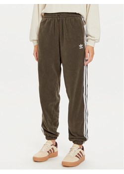 adidas Spodnie dresowe adicolor Polar IY7835 Khaki Loose Fit ze sklepu MODIVO w kategorii Spodnie damskie - zdjęcie 182744519