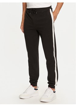 Tommy Hilfiger Spodnie dresowe UM0UM03013 Czarny Regular Fit ze sklepu MODIVO w kategorii Spodnie męskie - zdjęcie 182754678