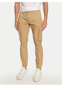 Calvin Klein Jeans Joggery J30J326438 Beżowy Skinny Fit ze sklepu MODIVO w kategorii Spodnie męskie - zdjęcie 183604535