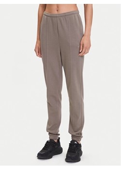 Nike Spodnie dresowe Chill Terry FN2434 Brązowy Regular Fit ze sklepu MODIVO w kategorii Spodnie damskie - zdjęcie 183620318