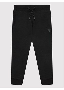 Guess Spodnie dresowe L2YQ46 KAIJ1 Czarny Regular Fit ze sklepu MODIVO w kategorii Spodnie chłopięce - zdjęcie 183631499