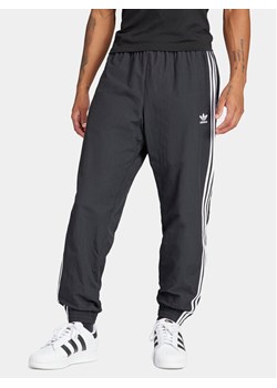 adidas Spodnie dresowe Adicolor Woven Firebird IT2501 Czarny Regular Fit ze sklepu MODIVO w kategorii Spodnie męskie - zdjęcie 183669669