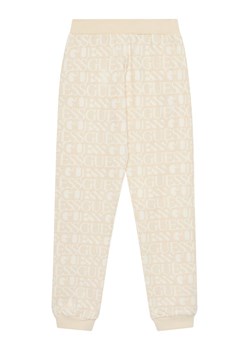 Guess Spodnie dresowe J5YQ13 KAD74 Beżowy Regular Fit ze sklepu MODIVO w kategorii Spodnie dziewczęce - zdjęcie 183885486