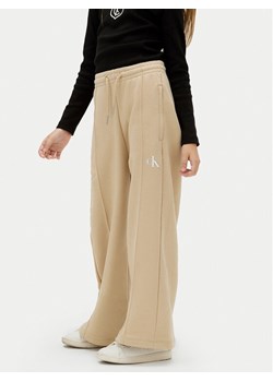 Calvin Klein Jeans Spodnie dresowe IG0IG02875 M Beżowy Wide Leg ze sklepu MODIVO w kategorii Spodnie dziewczęce - zdjęcie 183986095
