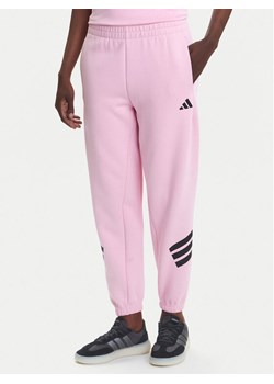 adidas Spodnie dresowe Future Icons 3-Stripes JE0158 Różowy Regular Fit ze sklepu MODIVO w kategorii Spodnie damskie - zdjęcie 184009935