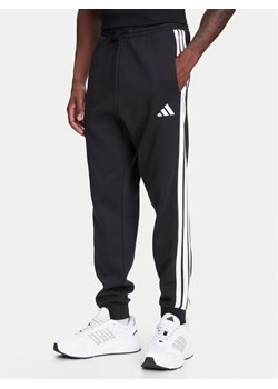 adidas Spodnie dresowe Essentials 3-Stripes JD1861 Czarny Regular Fit ze sklepu MODIVO w kategorii Spodnie męskie - zdjęcie 184019337