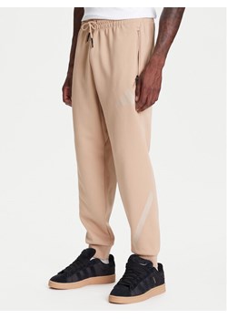 adidas Spodnie dresowe Z.N.E. JW4725 Beżowy Loose Fit ze sklepu MODIVO w kategorii Spodnie męskie - zdjęcie 184038436
