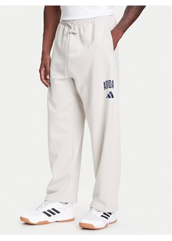 adidas Spodnie dresowe Collegiate JM9177 Beżowy Regular Fit ze sklepu MODIVO w kategorii Spodnie męskie - zdjęcie 184045645