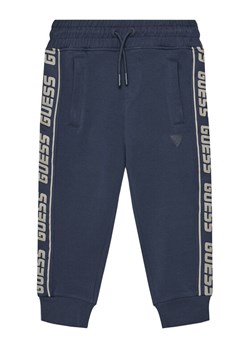Guess Spodnie dresowe L2YQ48 K6ZS1 Granatowy Regular Fit ze sklepu MODIVO w kategorii Bluzy chłopięce - zdjęcie 184103357