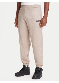 Guess Spodnie dresowe Z5YB03 KCJY2 Beżowy Regular Fit ze sklepu MODIVO w kategorii Spodnie męskie - zdjęcie 184158606