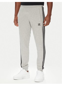 adidas Spodnie dresowe adicolor 3-Stripes JY1387 Szary Slim Fit ze sklepu MODIVO w kategorii Spodnie męskie - zdjęcie 184231798